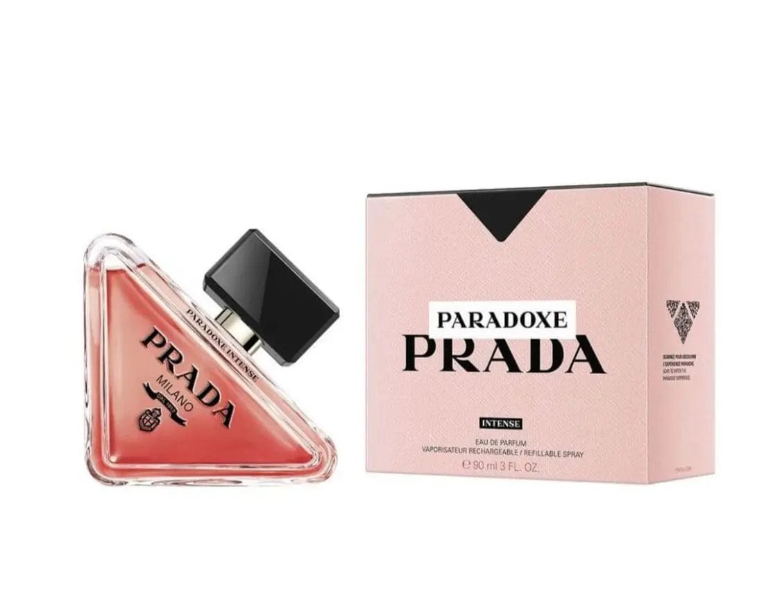 The Prada Paradoxe Intense 90ml Eau de Parfum spray bottle displayed next to its elegant, minimalist light pink presentation box.