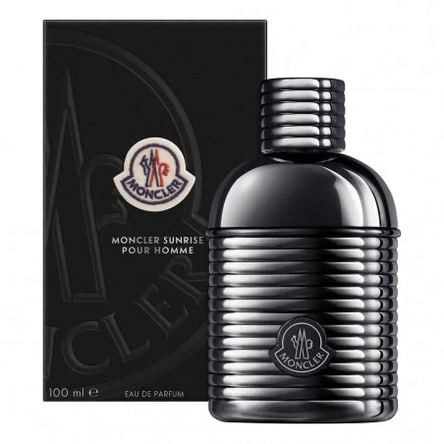 The Moncler Sunrise Pour Homme perfume bottle, with its unique ribbed design and matte black finish, displayed next to its elegant black box. The image showcases the complete, luxurious presentation of the product.